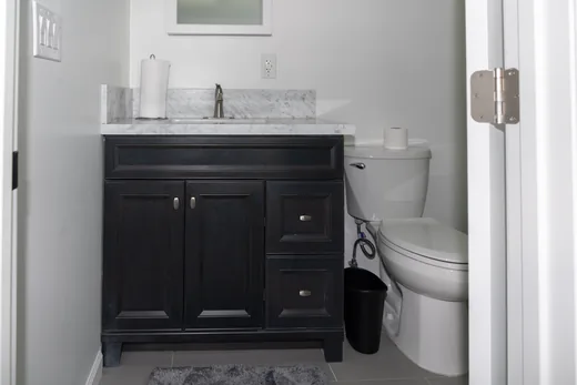Powder room with a dark vanity and white counter