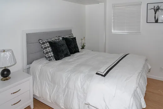 Primary bedroom with an upholstered headboard and daylight from the window