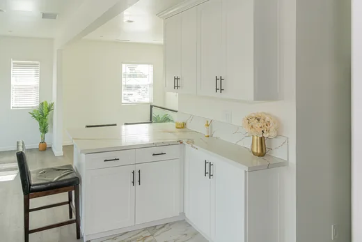 Kitchen with a large quartz waterfall island and bar seating