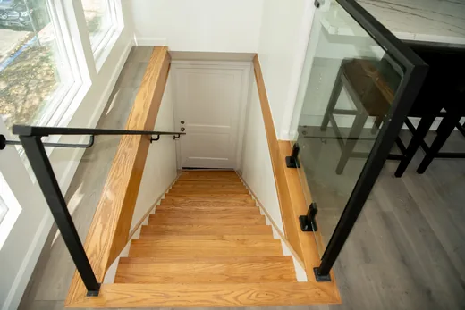 Wood-tread staircase with a glass and black metal railing